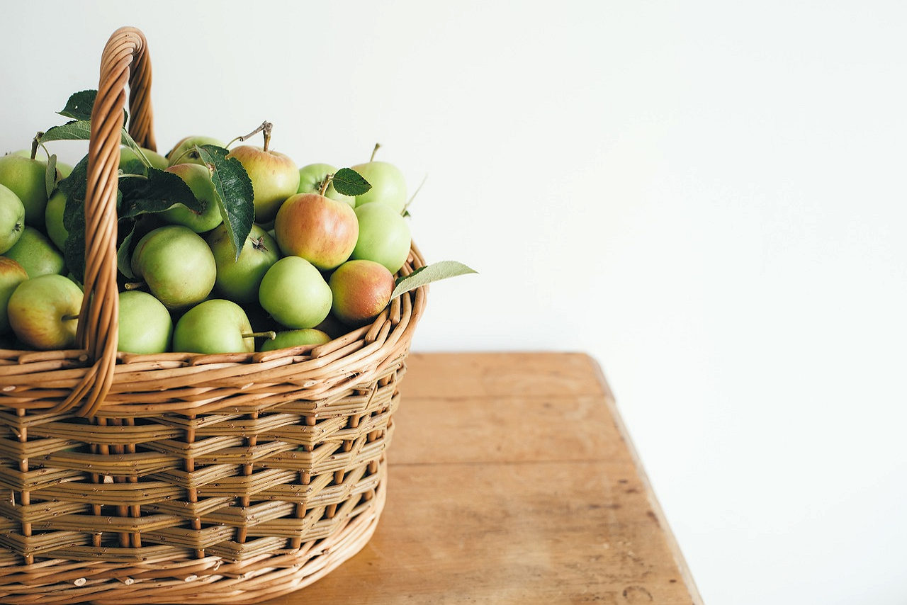 Basket of apples sitting on a table